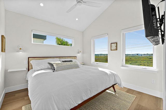 bedroom featuring ceiling fan, light hardwood / wood-style flooring, and lofted ceiling