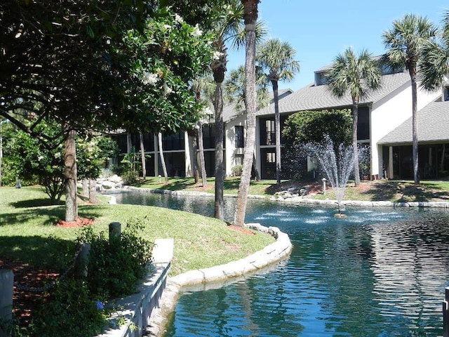 view of property's community featuring a water view and a yard