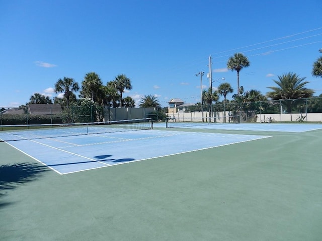 view of tennis court featuring fence