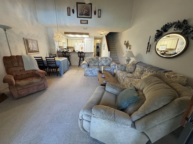 living room with stairway, a towering ceiling, and light colored carpet