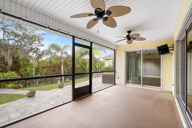 unfurnished sunroom with ceiling fan