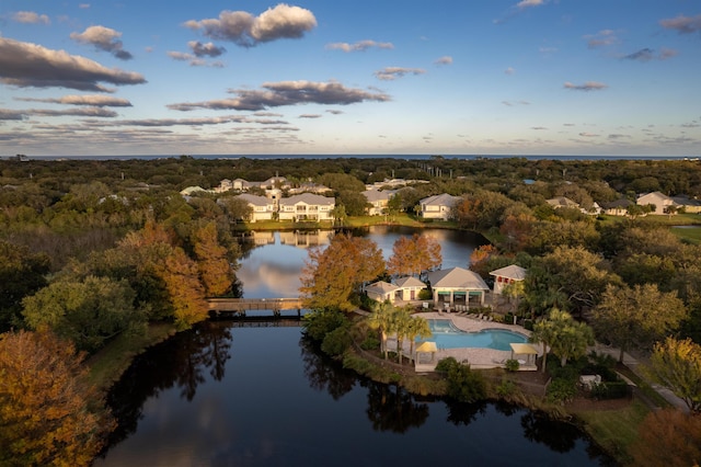 aerial view at dusk featuring a water view