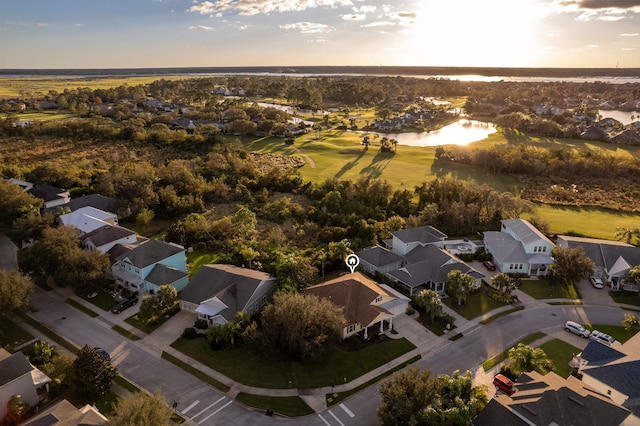 aerial view at dusk featuring a water view