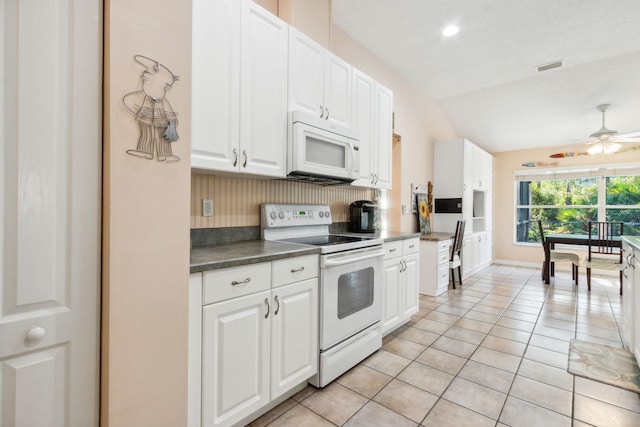 kitchen featuring white appliances, white cabinets, vaulted ceiling, ceiling fan, and tasteful backsplash