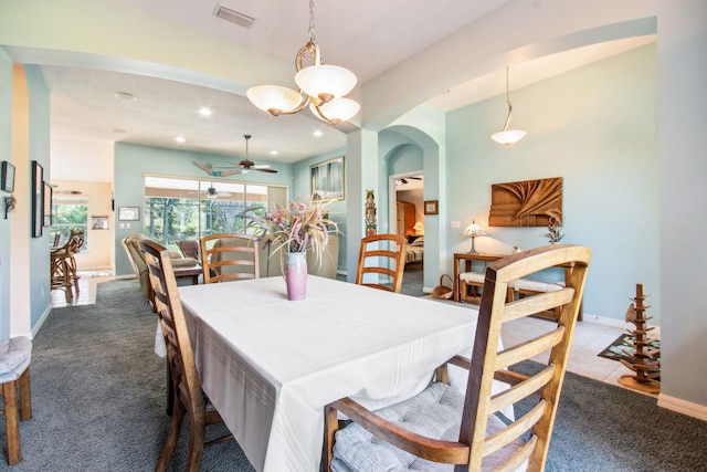 dining area with carpet floors and ceiling fan with notable chandelier