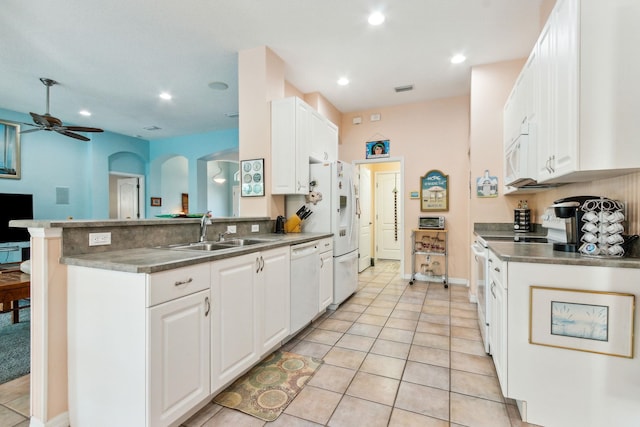 kitchen with kitchen peninsula, white appliances, ceiling fan, sink, and white cabinetry