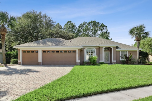 ranch-style home with a garage and a front lawn