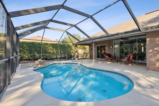 view of swimming pool with a lanai, ceiling fan, and a patio area