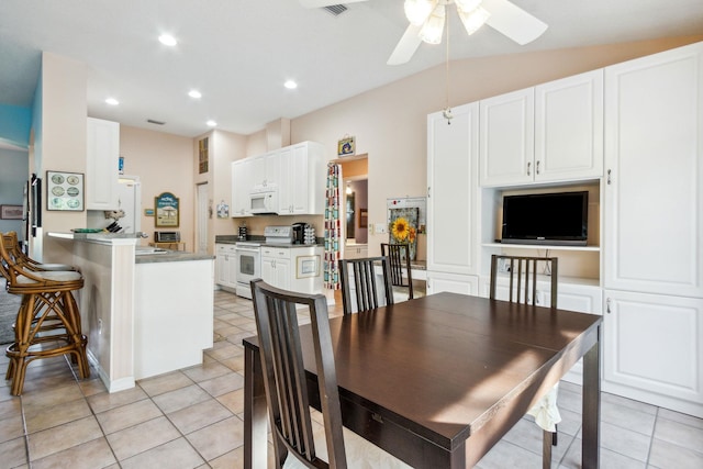 tiled dining space featuring vaulted ceiling and ceiling fan