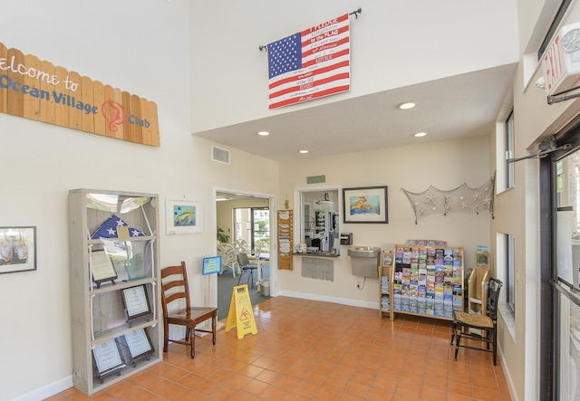 4250 A1A Unit E31, Saint Augustine Beach, FL 32080 - sitting room featuring tile patterned flooring, baseboards, recessed lighting, and a towering ceiling