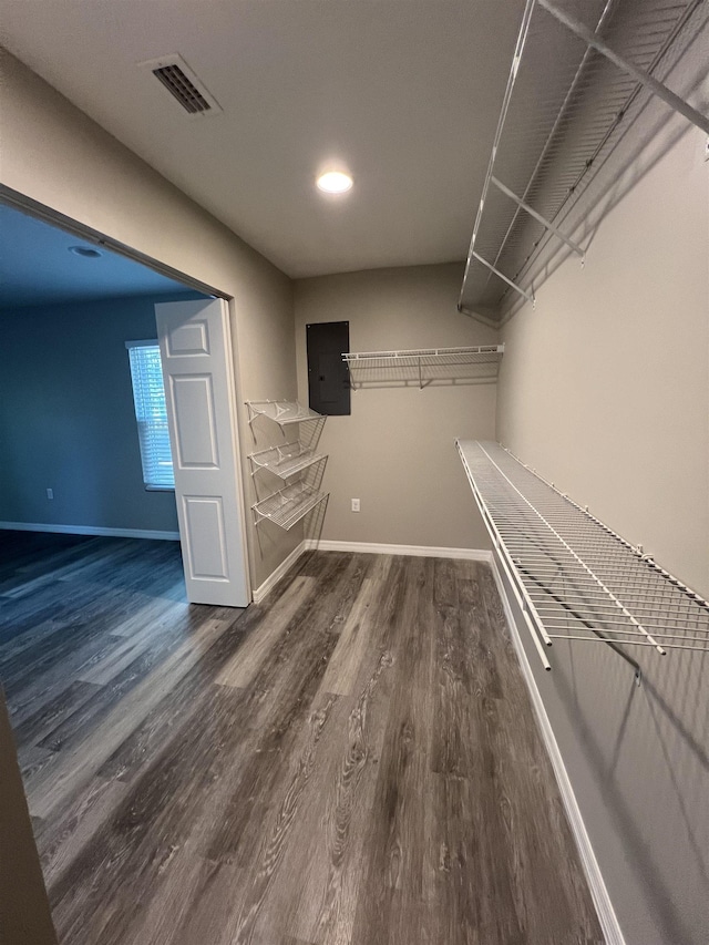 walk in closet with dark wood-type flooring and electric panel