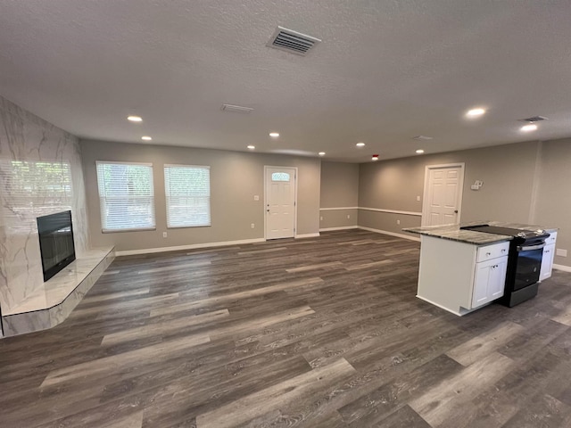 unfurnished living room with a textured ceiling, dark hardwood / wood-style floors, and a fireplace