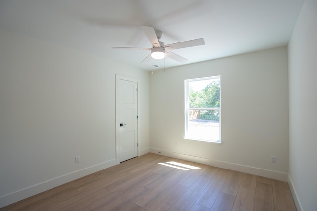 spare room with ceiling fan, baseboards, and light wood finished floors