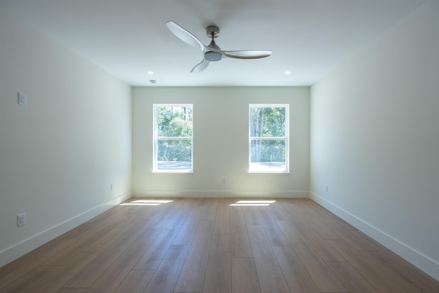 unfurnished room with wood finished floors, baseboards, and ceiling fan