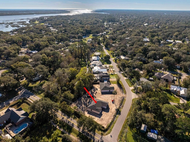 drone / aerial view with a residential view, a wooded view, and a water view