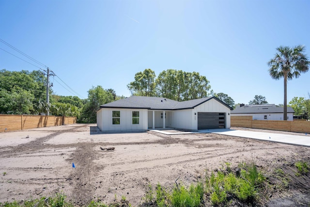 ranch-style home featuring concrete driveway, an attached garage, and fence