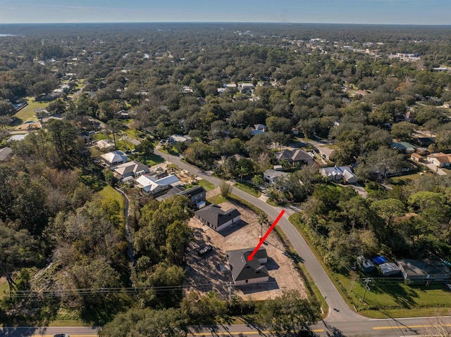 birds eye view of property featuring a wooded view and a residential view