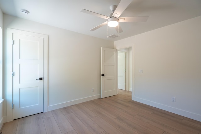 unfurnished bedroom with light wood finished floors, baseboards, a ceiling fan, and visible vents
