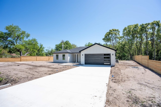 view of front of property with a garage, driveway, and fence