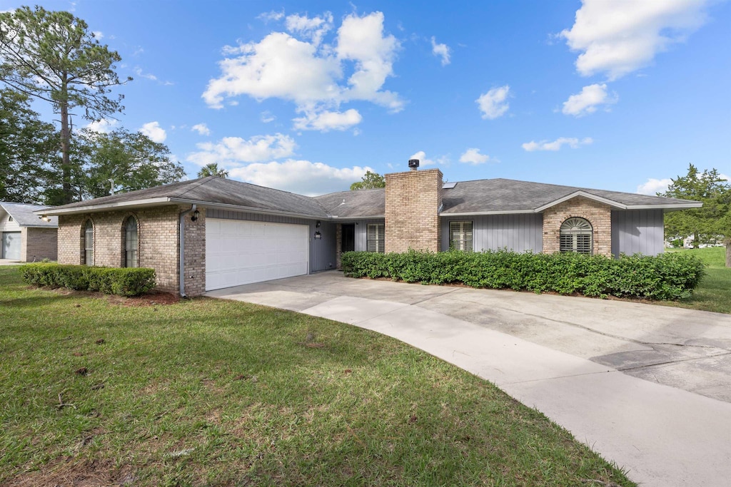 ranch-style house featuring a garage and a front lawn