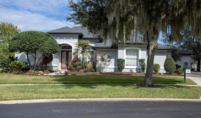 view of front of home with a front yard, french doors, and stucco siding