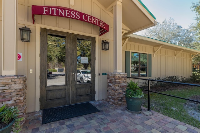 property entrance with stone siding and board and batten siding