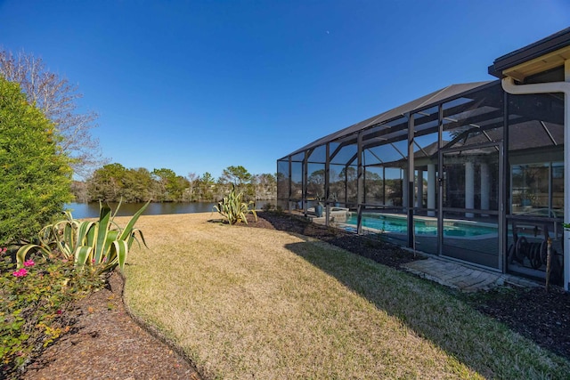 view of yard with glass enclosure, a water view, and an outdoor pool