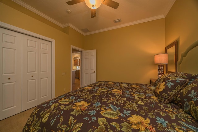 bedroom featuring carpet floors, a ceiling fan, visible vents, a closet, and crown molding