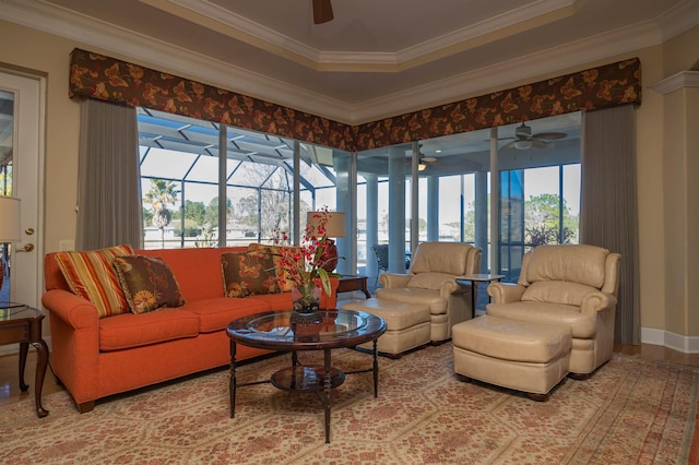 living room featuring ornamental molding, a tray ceiling, a wealth of natural light, and a sunroom