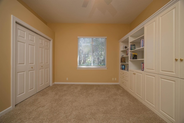 unfurnished bedroom with light carpet, ceiling fan, and baseboards