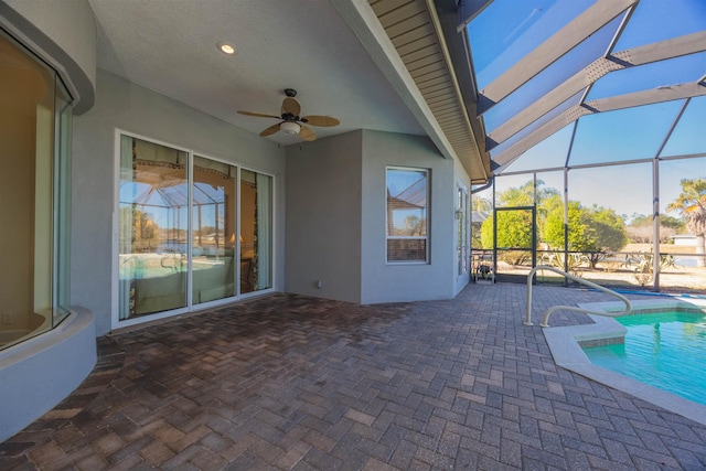 outdoor pool with ceiling fan, a patio, and glass enclosure