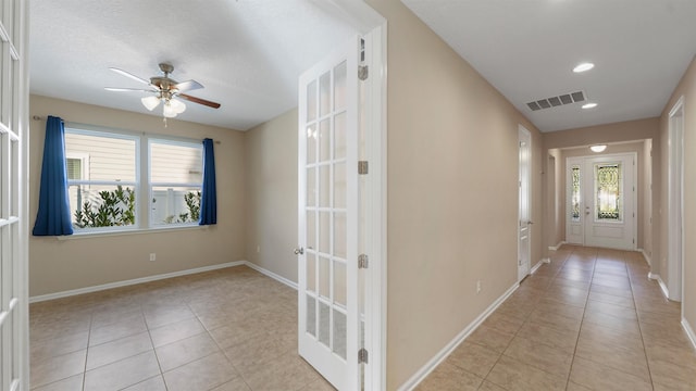 hallway with light tile patterned floors and french doors