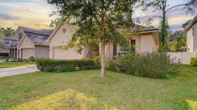 view of front of property with a garage and a lawn