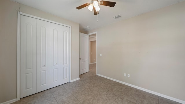 unfurnished bedroom featuring ceiling fan and a closet