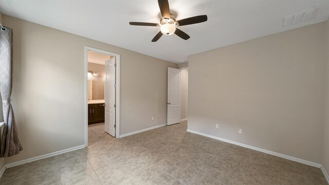 unfurnished bedroom featuring ceiling fan and ensuite bathroom