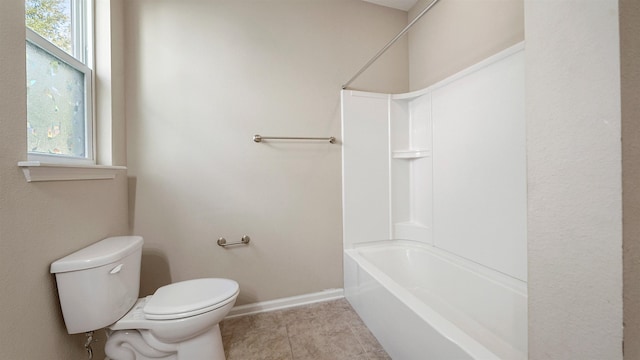 bathroom with tile patterned flooring, a healthy amount of sunlight, shower / bathtub combination, and toilet