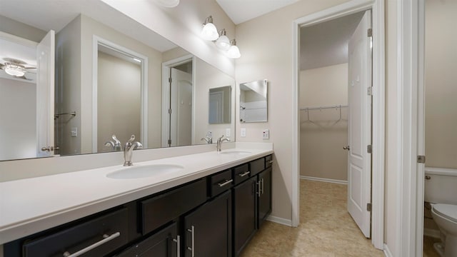 bathroom with vanity, toilet, and ceiling fan