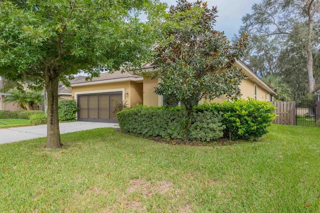 view of property hidden behind natural elements featuring a garage and a front lawn