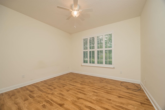 empty room featuring a textured ceiling, light hardwood / wood-style flooring, and ceiling fan