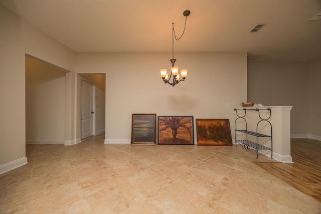 unfurnished room featuring light wood-type flooring and a notable chandelier