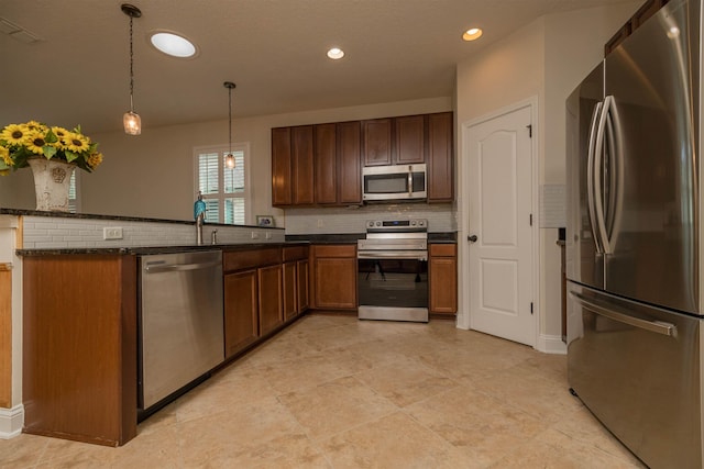 kitchen with decorative light fixtures, dark stone countertops, kitchen peninsula, and stainless steel appliances