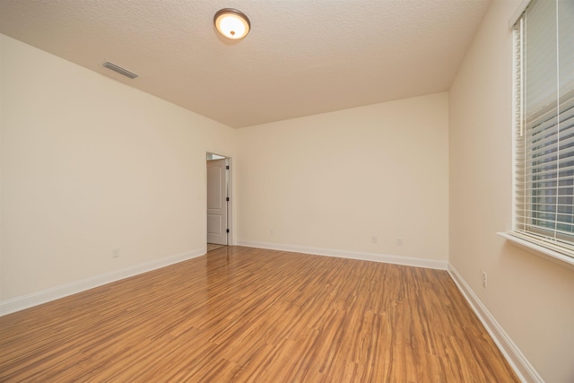 empty room featuring hardwood / wood-style flooring and a textured ceiling