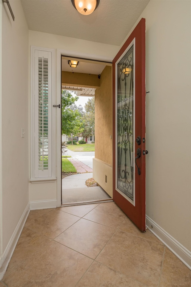 doorway to outside featuring light tile patterned flooring