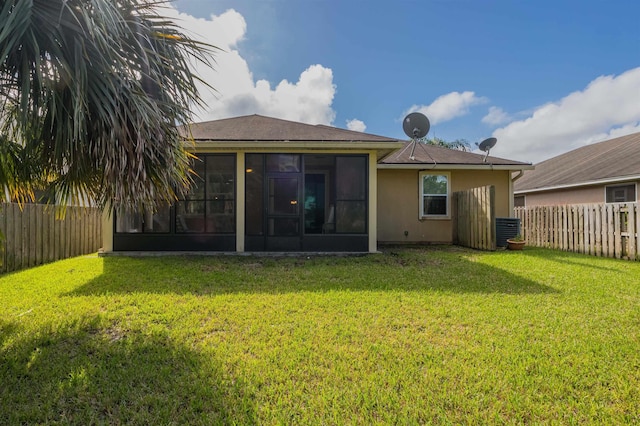 back of property with a lawn and a sunroom