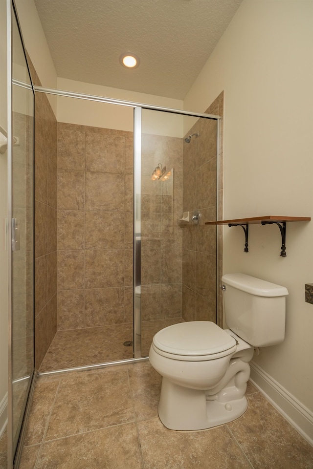 bathroom with a textured ceiling, tile patterned flooring, an enclosed shower, and toilet