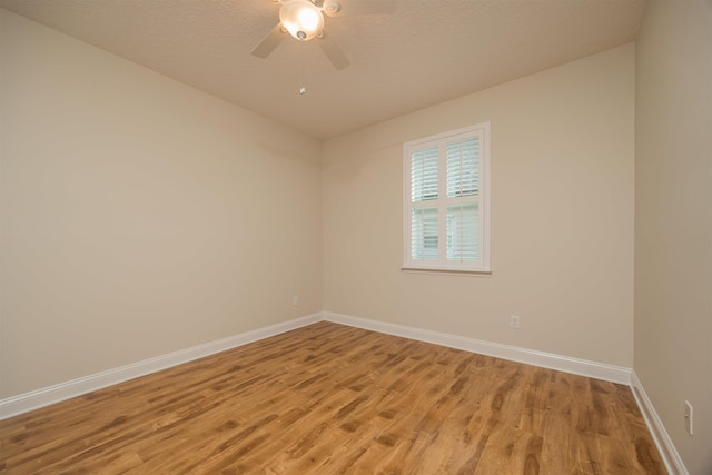 unfurnished room with hardwood / wood-style flooring, ceiling fan, and a textured ceiling