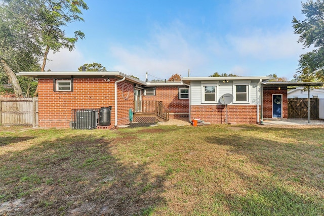 back of house featuring central AC unit and a lawn