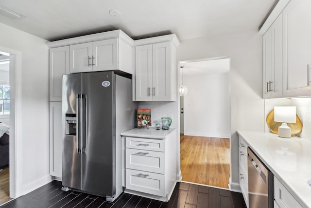 kitchen with appliances with stainless steel finishes, dark hardwood / wood-style flooring, and white cabinetry