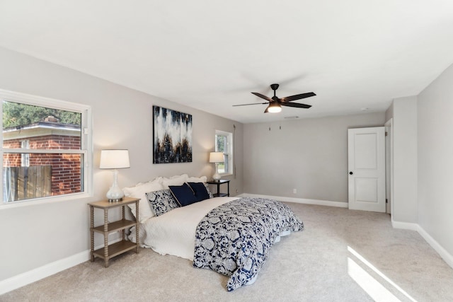 carpeted bedroom with multiple windows and ceiling fan