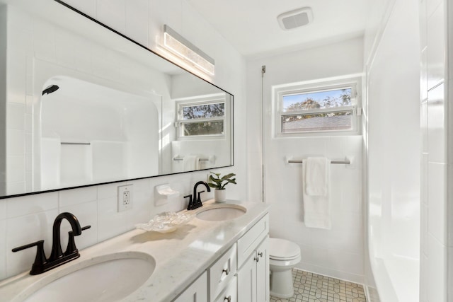 bathroom with decorative backsplash, vanity, tile walls, and toilet